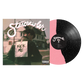 Starcrawler’s Kick Me album cover features a person in a leather jacket with a sign reading KICK ME on their back, alongside a split-design pink and black speckled vinyl record and the music album tracklisting.