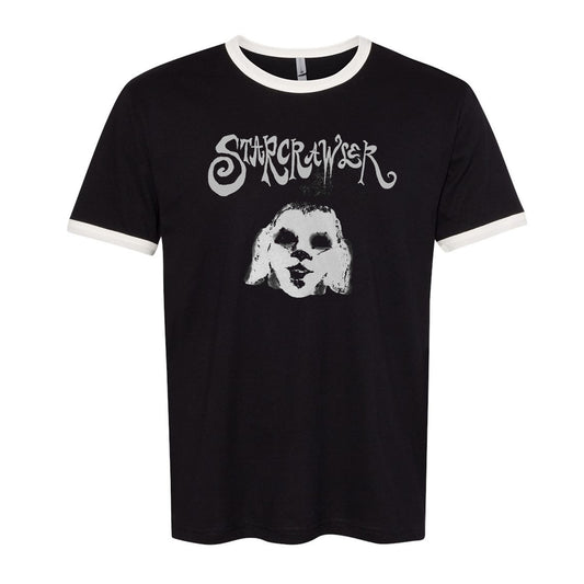 image of a black and white ringer tee on a white background. front of tee has grey print of a spooky face. at the top across the chest says starcrawler